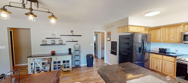 kitchen featuring a textured ceiling, light hardwood / wood-style flooring, light brown cabinetry, and stainless steel appliances