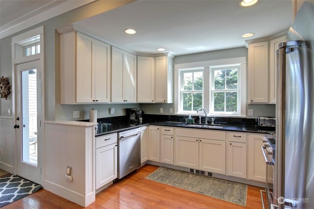 kitchen featuring stainless steel appliances, a sink, visible vents, and light wood-style floors