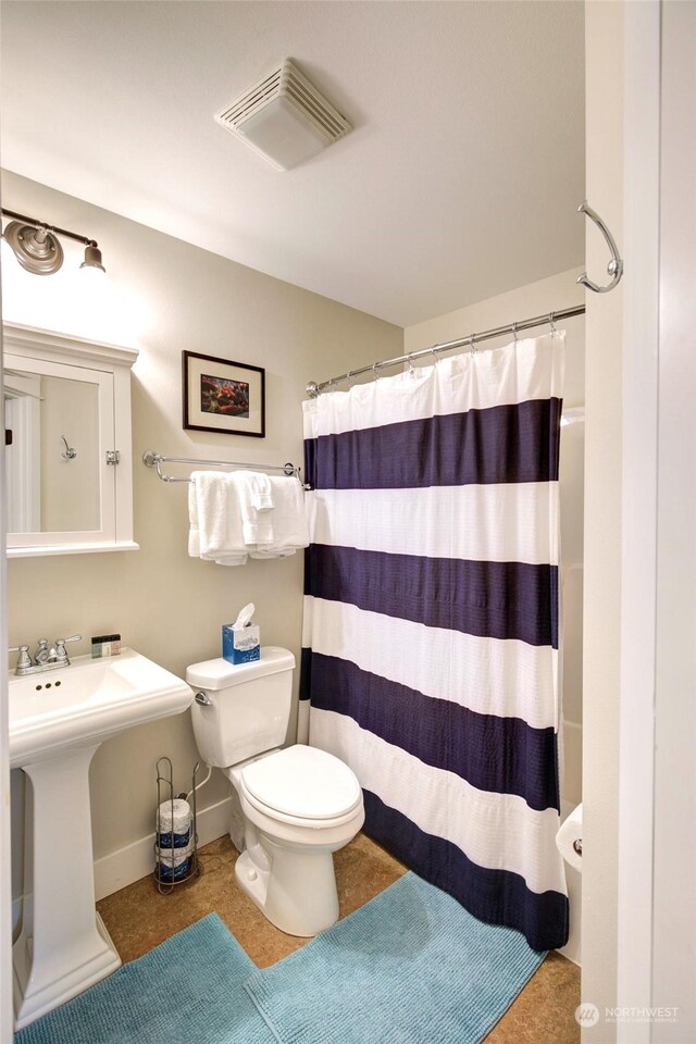 full bath featuring toilet, curtained shower, visible vents, and baseboards