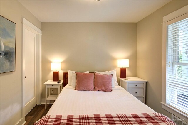 bedroom with dark wood-style flooring