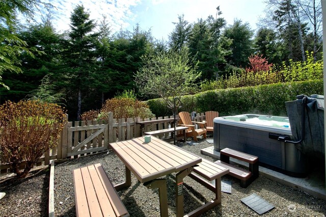 view of patio featuring a hot tub and fence