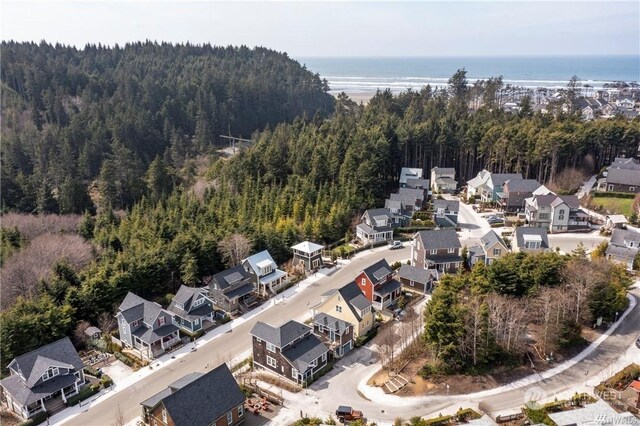 drone / aerial view with a residential view, a water view, and a view of trees