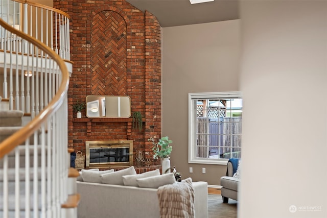 living room featuring a high ceiling and a brick fireplace