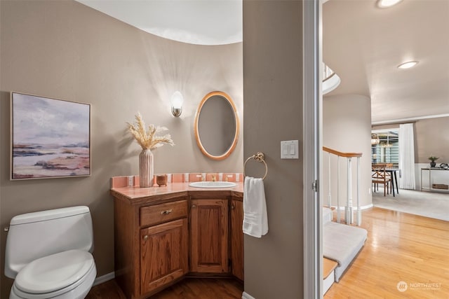 bathroom featuring hardwood / wood-style flooring, vanity, and toilet