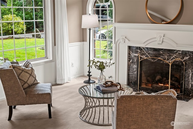 living area with light carpet and a high end fireplace