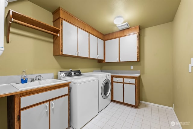 washroom featuring independent washer and dryer, sink, cabinets, and light tile patterned flooring