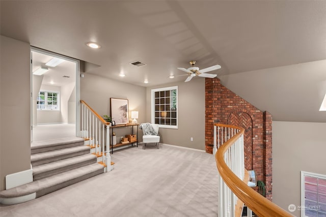 living area with light carpet, vaulted ceiling, and ceiling fan