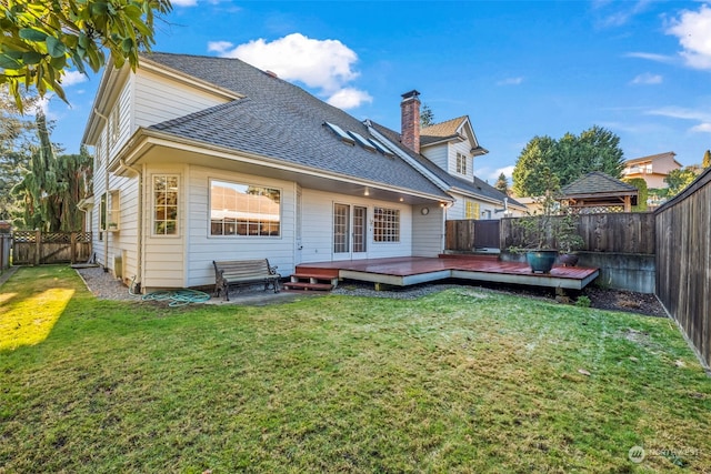 back of house featuring a wooden deck and a lawn