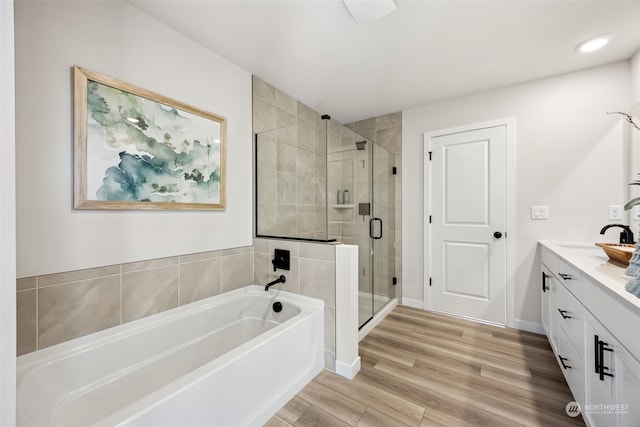 bathroom with vanity, wood-type flooring, and plus walk in shower