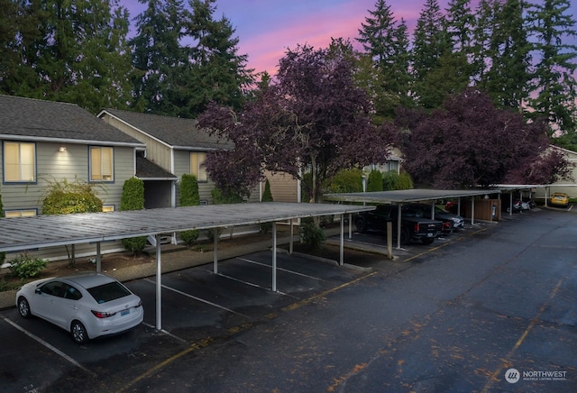 parking at dusk featuring a carport