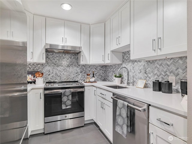 kitchen with stainless steel appliances, white cabinetry, sink, and decorative backsplash