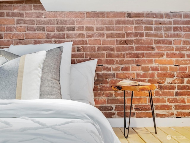 unfurnished bedroom featuring brick wall