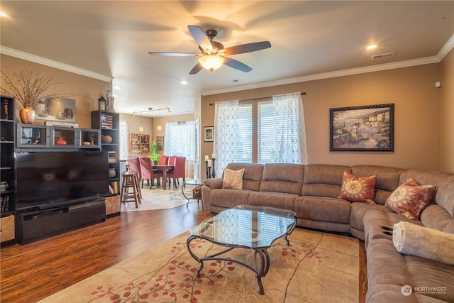 living room featuring crown molding, ceiling fan, rail lighting, and hardwood / wood-style flooring