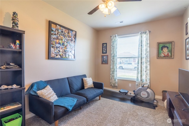 carpeted living room with ceiling fan