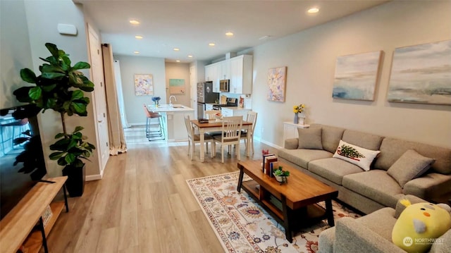 living room with light wood-type flooring and sink