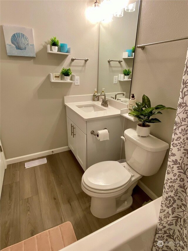 bathroom with vanity, toilet, and hardwood / wood-style flooring