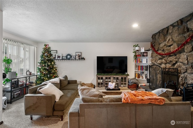 living room with a fireplace, light colored carpet, and a textured ceiling