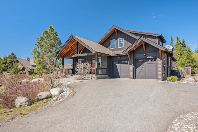 view of front of property with a porch, a garage, and central AC unit