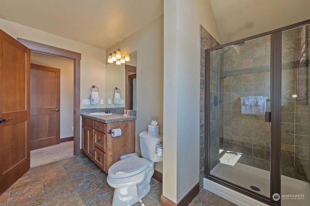 bathroom with vanity, a shower with shower door, vaulted ceiling, and toilet