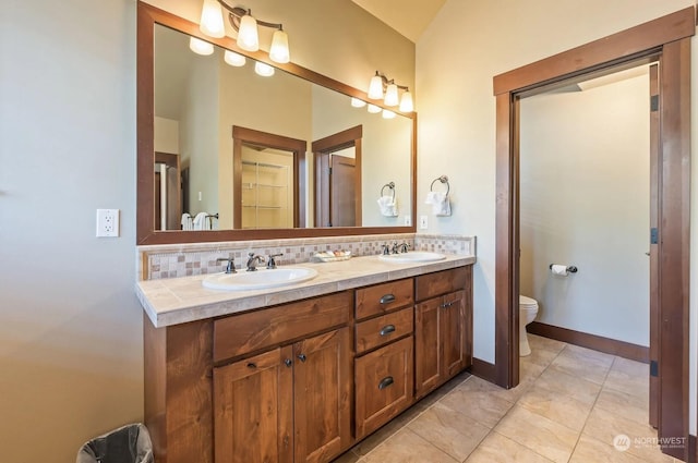 bathroom with toilet, tasteful backsplash, tile patterned floors, and vanity
