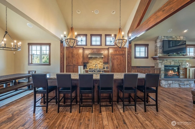 interior space with dark wood-type flooring, high vaulted ceiling, and a notable chandelier