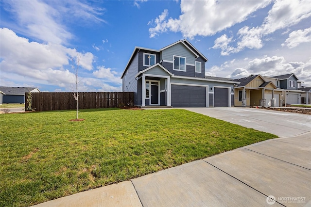 traditional home with a garage, fence, driveway, and a front lawn