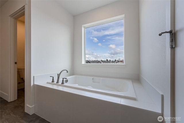 bathroom featuring toilet and a bath