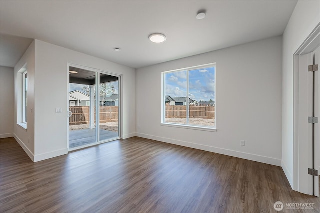 unfurnished bedroom with baseboards, dark wood-type flooring, and access to exterior