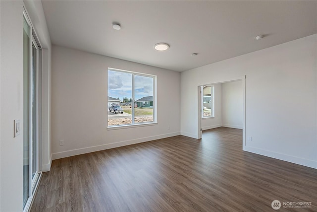 unfurnished room featuring dark wood-style flooring and baseboards