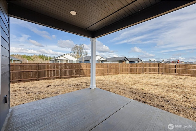 view of yard featuring a patio area, a fenced backyard, and a residential view