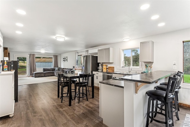 12504 SW 232nd St, Vashon, WA 98070 - kitchen featuring dark countertops, a kitchen bar, a peninsula, stainless steel appliances, and dark wood-type flooring