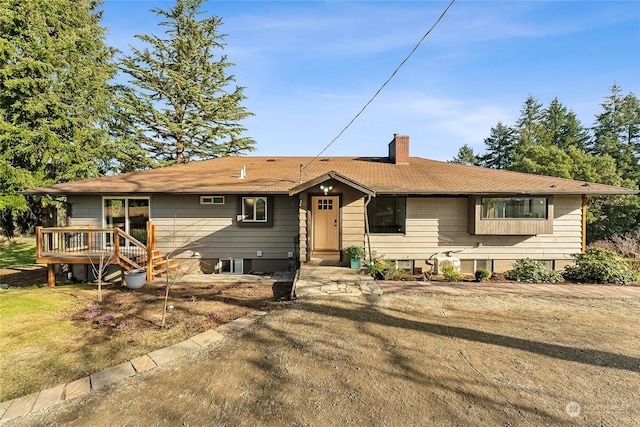 ranch-style home featuring a deck and a chimney