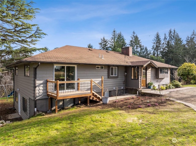 rear view of house with a chimney, a wooden deck, and a lawn