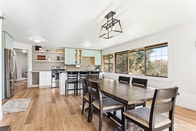 dining area with baseboards and light wood-style floors