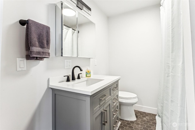 full bathroom featuring toilet, tile patterned flooring, baseboards, and vanity