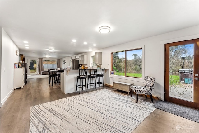 interior space with baseboards, wood finished floors, and recessed lighting