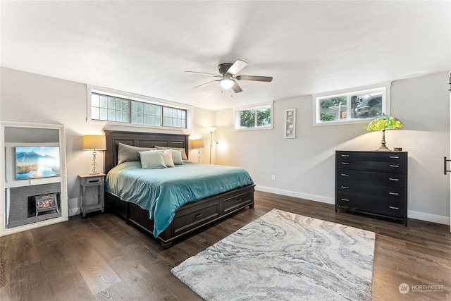 bedroom featuring ceiling fan, baseboards, and dark wood finished floors