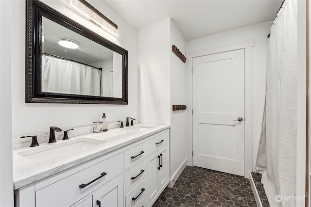 full bathroom with double vanity, a sink, and tile patterned floors