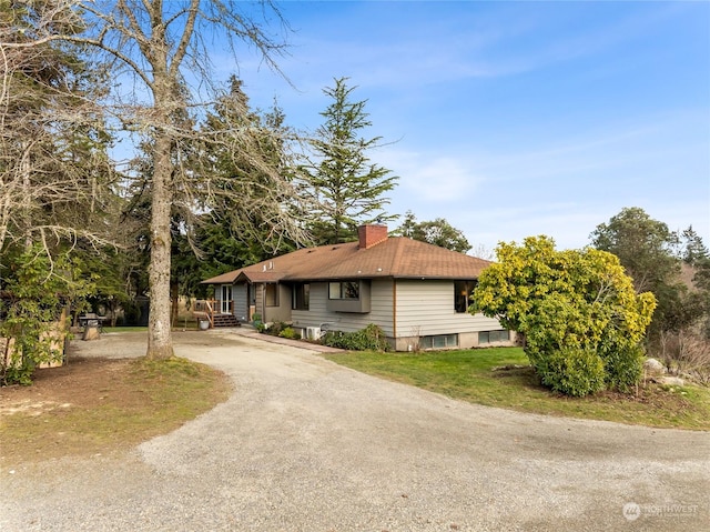 view of property exterior with driveway and a chimney