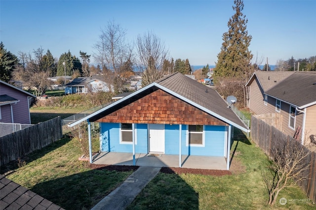 rear view of house featuring a patio and a lawn