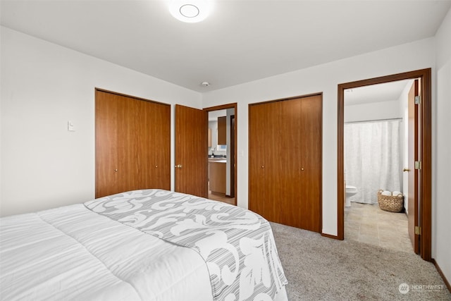 bedroom featuring ensuite bathroom and light carpet