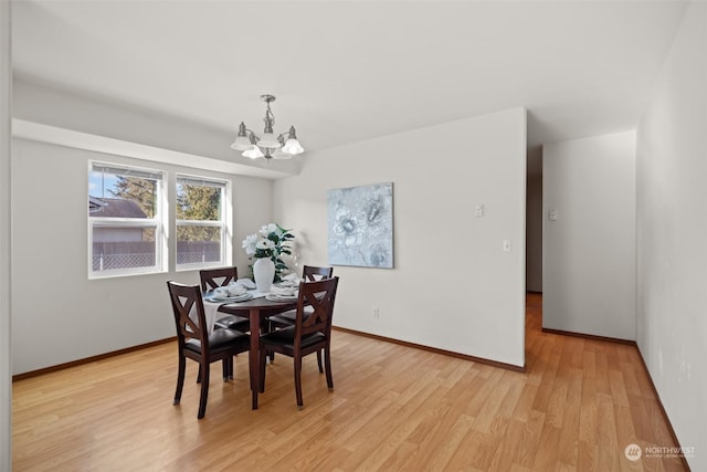 dining area with an inviting chandelier and light hardwood / wood-style flooring