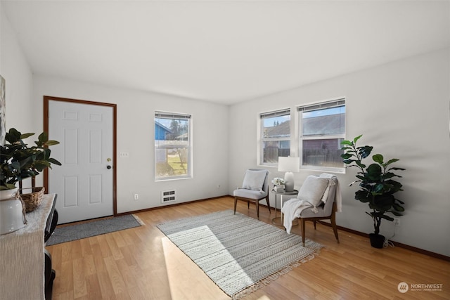 foyer entrance with heating unit and light wood-type flooring