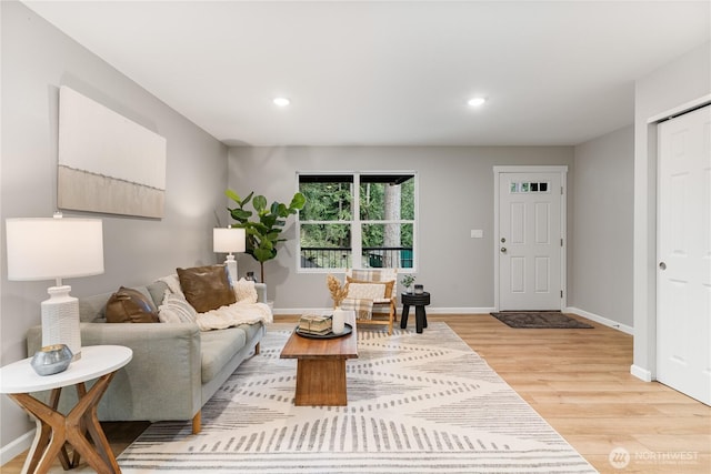 living area with light wood-style flooring, recessed lighting, and baseboards