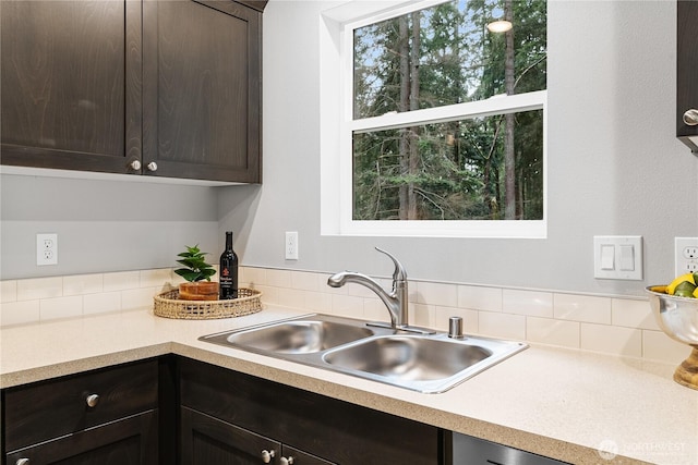 kitchen featuring light countertops, dark brown cabinets, and a sink