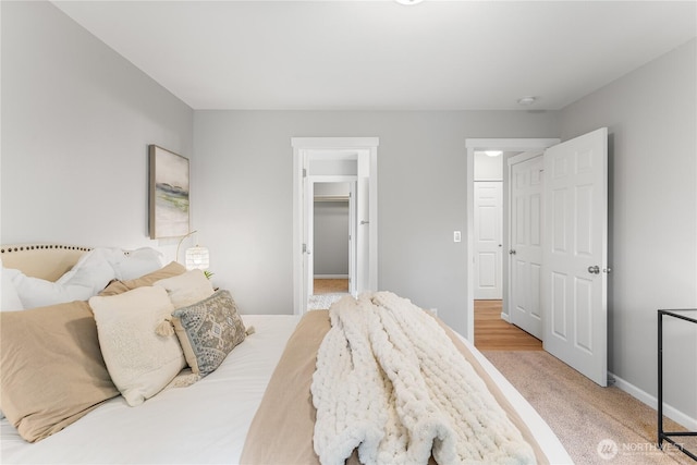 bedroom featuring a spacious closet and baseboards