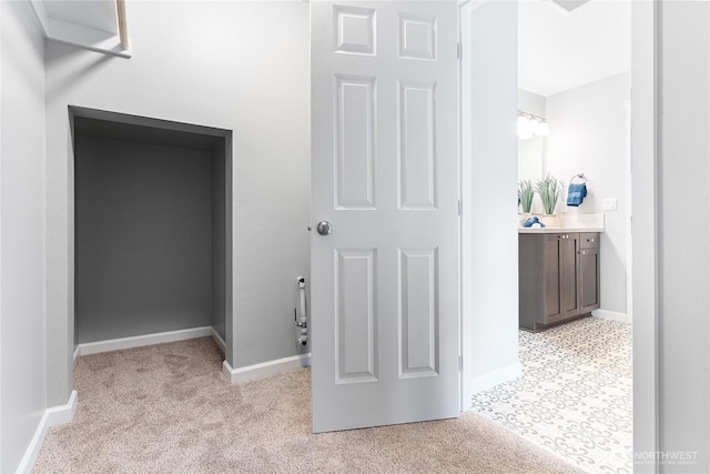 hall with baseboards and light carpet