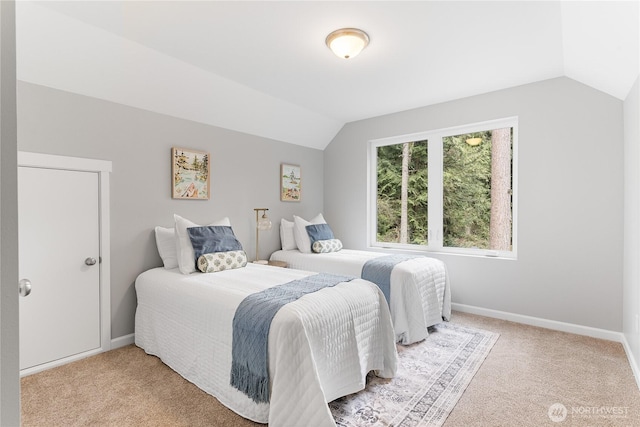 bedroom with baseboards, light colored carpet, and vaulted ceiling