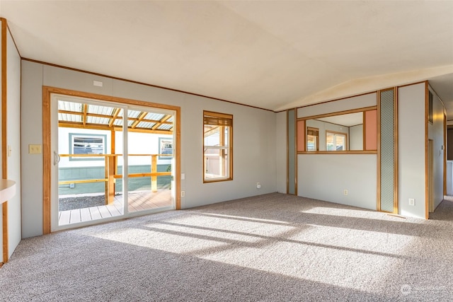 carpeted empty room featuring vaulted ceiling