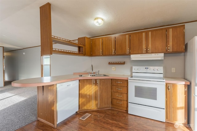 kitchen featuring sink, white appliances, kitchen peninsula, and wood-type flooring